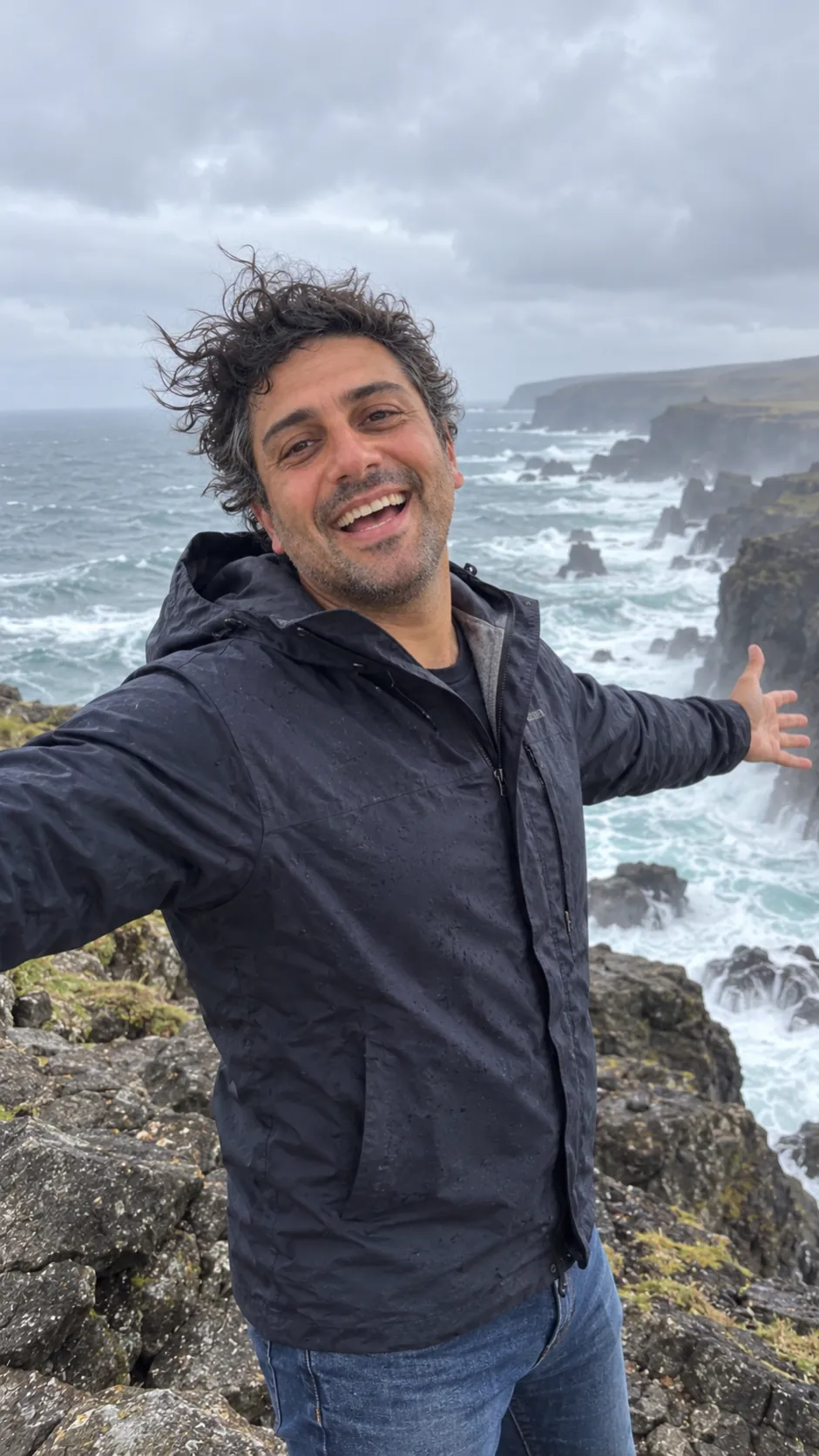 AI-generated example of a future self: a man laughing on a rocky coastline on a windy, overcast day.