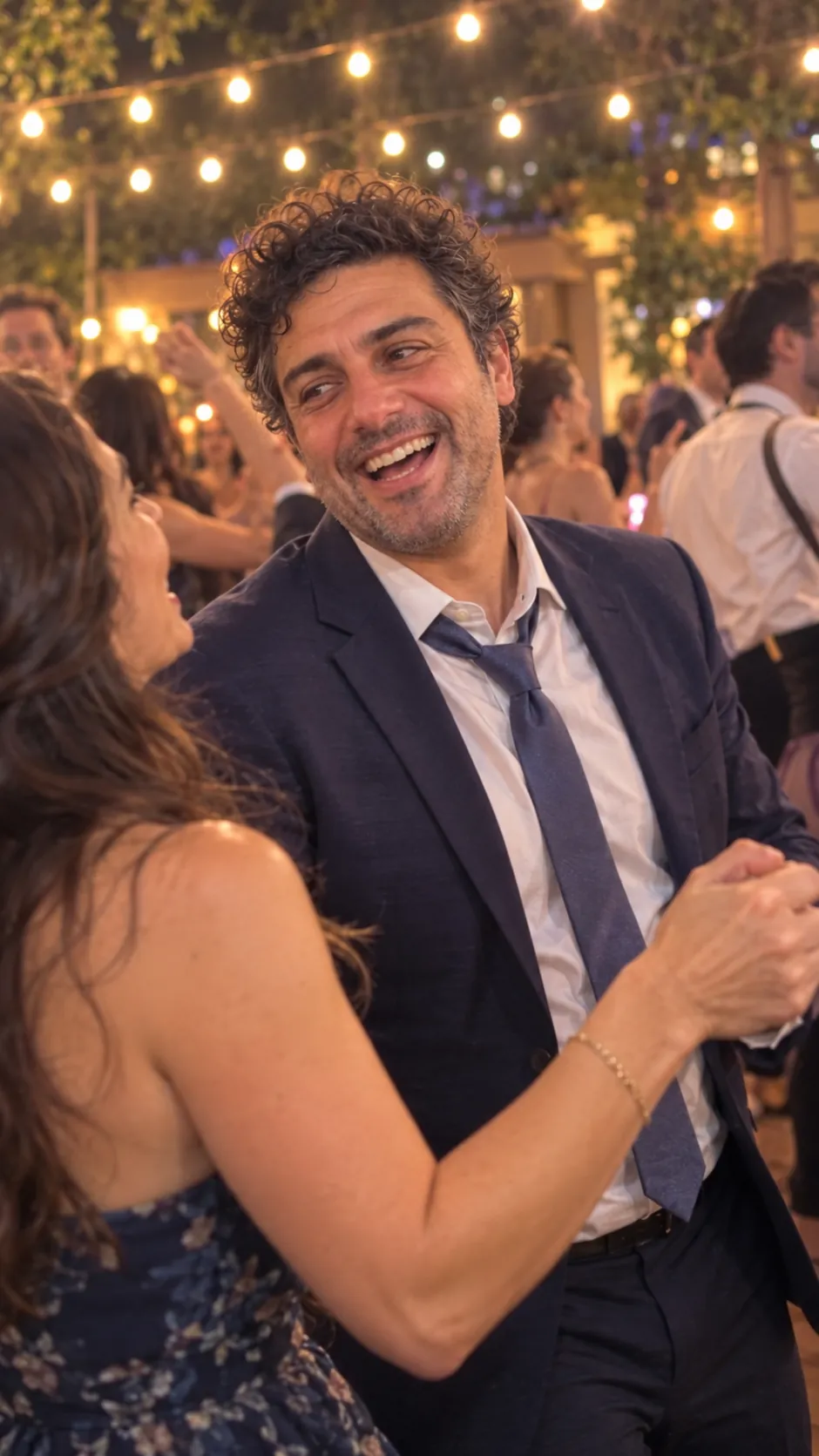 AI-generated example of a future self: a man in a suit dancing at a wedding under string lights.